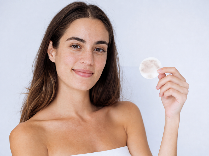 Mujer mostrando el algodón después de limpiar su rostro